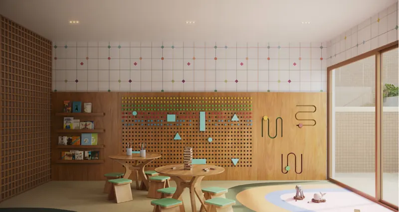 Espaço kids do Soul Rio Gago Coutinho com mesinhas de madeira e painel de brincar